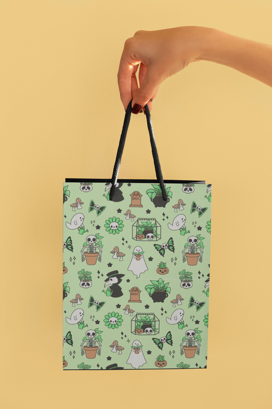 a hand holding a shopping bag with a pattern of plants